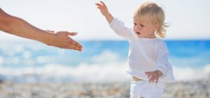 Baby walking to mothers outstretched hands